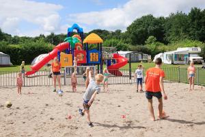 霍尔滕Luxe kamperen bij Procamp4all的一群儿童在游乐场的沙地玩耍