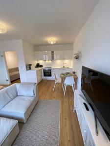 维斯马Smultron Apartment Altstadt Wismar的一间带白色沙发的客厅和一间厨房
