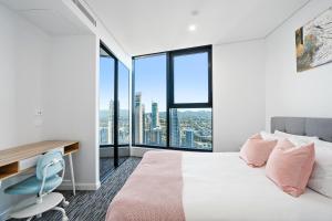 黄金海岸Surfers Paradise New Beachfront 2&3 BED APT的卧室配有一张床、一张书桌和窗户。