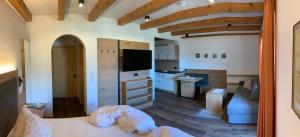拉古多Garni & Residence Sonngart的一间带一张床的房间和一间带厨房的客厅