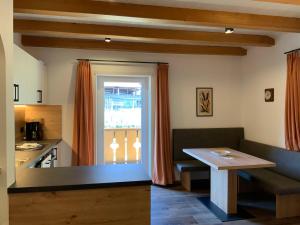 拉古多Garni & Residence Sonngart的厨房配有桌子、窗户和桌子
