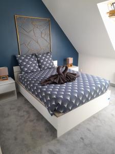拉尼翁Appartements Lannion proche centre, Côtes de Granit Rose的一间卧室配有一张蓝色墙壁的床