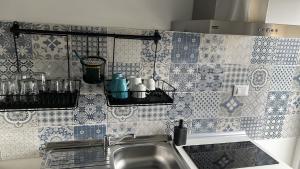 利沃诺ACCADEMIA Rooms的厨房的墙壁上铺有蓝色和白色的瓷砖。