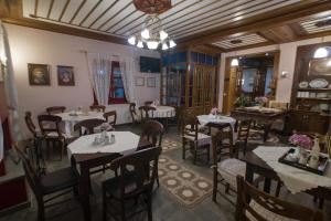 AsprangeloiMeliteion Traditional Hotel的一间带桌椅和吊灯的餐厅