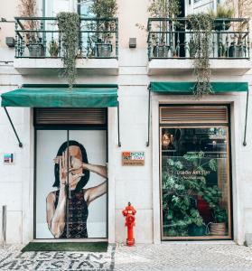里斯本Lisbon Art Stay Apartments Baixa的商店前方的窗户上挂着一张女人的照片