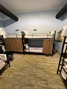 第比利斯Tbil Home Hostel的客房设有三张双层床,铺有木地板。
