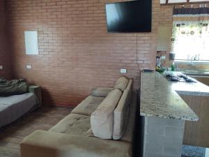 莫日-达斯克鲁济斯Chácara Buscapé的客厅配有沙发和砖墙电视