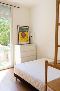 马赛LE PETIT NID DES CHUTES LAVIES的卧室配有一张床,墙上挂有绘画作品