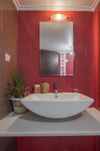 普雷韦扎Villa Manolia的红色墙壁浴室内的一个大型白色水槽