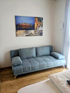 克拉根福215 Apartment Wien 4-6 Pers 42m2的客厅里一张蓝色的沙发,墙上挂着一幅画
