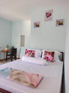 纳闽巴霍Cowang Dereng Home Stay的一间卧室,床上有粉红色的鲜花