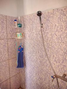 纳闽巴霍Cowang Dereng Home Stay的瓷砖墙上的蓝色毛巾淋浴