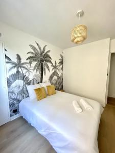 罗阿纳La Douceur Roannaise - Parking privé proche gare的卧室配有一张带黄色枕头的大型白色床。
