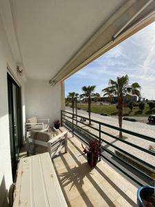 卡帕里卡海岸Atlantic Lodge, 1ª linha de praia!的阳台享有大海和棕榈树的景致。