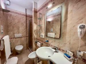 坎普码头Hotel Meridiana的一间带水槽、卫生间和镜子的浴室