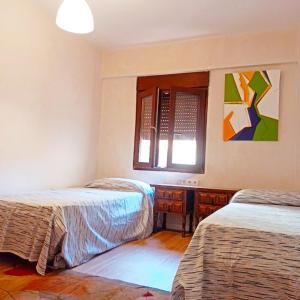 布尔哈索特Vistas a las palmeras的一间卧室设有两张床和窗户。