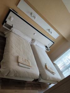 卢尔德Hotel Du Rocher的配有2个白色枕头的客房内的一张床位
