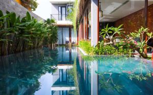 岘港K-House vs Apartment的植物繁茂的建筑中间的游泳池