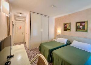 坎普码头Hotel Meridiana的酒店客房设有两张床和一张桌子。