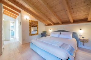 莫尔韦诺Attico con vista sul lago e montagne a Molveno的一间卧室设有一张大床和木制天花板