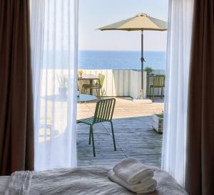 古兹耶姆Hotel Klippen的一间卧室享有带遮阳伞的庭院的景致。
