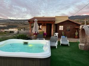 吉亚德伊索拉La Cabaña的一座位于房子旁草坪上的热水浴池