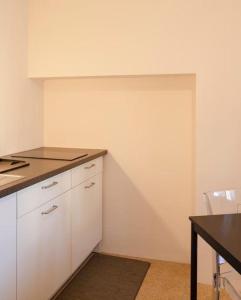 门德里西奥Relais Flora Arzo Appartamento superior di vacanza con posteggio的厨房配有白色橱柜、桌子和柜台。