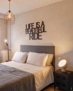 门德里西奥Relais Flora Arzo Appartamento superior di vacanza con posteggio的一间卧室,床上有写着读书的标志,生活是美丽的旅程