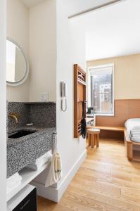 纽约UNTITLED 3 Freeman Alley的一间带水槽的浴室和一张位于客房内的床