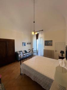 圣凯撒利亚温泉Mare, Terme & Magia Salentina的一间卧室配有一张大床和一张沙发