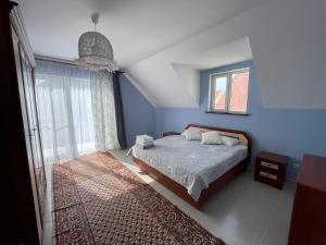 乔尔蓬阿塔Коттедж на берегу Иссык-Куля的蓝色的卧室设有床和窗户