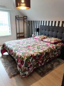 圣库隆CHEZ HÉLÈNE的一间卧室配有一张带花卉床罩的床