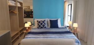 马塞约Edf Time Ponta Verde, Studio 523的一间卧室配有一张蓝色墙壁的床和两盏灯。
