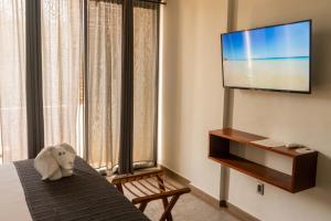 图卢姆Hotel Muyu Tulum的一间酒店客房,配有电视,桌子上放着大象
