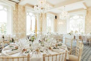 什鲁斯伯里Rowton Castle的用餐室配有白色桌椅和吊灯。