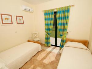 萨米Dafni (2 bedrooms, sleeps 4)的一间卧室设有两张床和窗户。