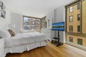 纽约Global Luxury Suites at The Marc的一间卧室配有一张床和一台平面电视
