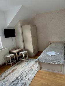 大特尔诺沃Apartment VEDA 2的一间卧室配有一张床、一个橱柜和一台电视