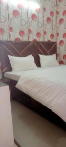 钱德加尔Hotel king palace的一张带白色床单和枕头的床