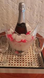 圣米格尔-杜斯米拉格里斯NORI POUSADA的一瓶香槟酒,放进碗里,放进两杯酒杯