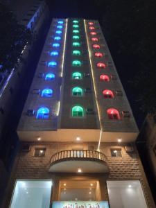 麦加Najmat Alnoor Almaabdah Hotel的建筑的侧面有彩色灯