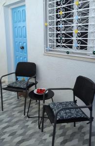 勾芒普莱奇Chez Ayedi - central and familiar atmosphere next to beach的一间设有两把椅子、一张桌子和一个窗户的房间