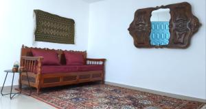 勾芒普莱奇Chez Ayedi - central and familiar atmosphere next to beach的客厅配有红色的沙发和镜子