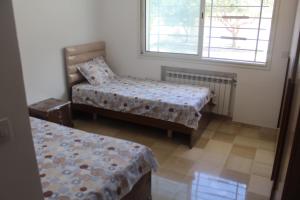 RejicheRelaxing Vacation Stay in Mahdia的客房设有两张床、一把椅子和窗户。