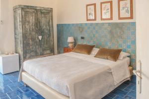 圣尼科拉阿尔切拉La casa nel borgo的一间卧室设有一张床和蓝色瓷砖墙