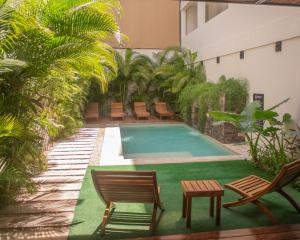 图卢姆Hotel Muyu Tulum的一座带椅子的建筑中央游泳池