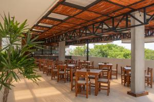 图卢姆Hotel Muyu Tulum的餐厅设有木桌和椅子,种有植物