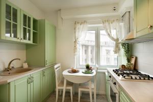 布加勒斯特METROPOLE APARTMENTS ATENEUM RESIDENCE的厨房配有绿色橱柜和水槽