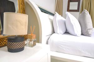 哈博罗内acaciaoptimumstay的一间卧室配有带白色枕头的床