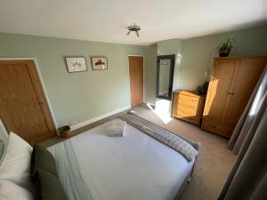 LincolnshireRasen Cottage的卧室配有白色的床和木制梳妆台。